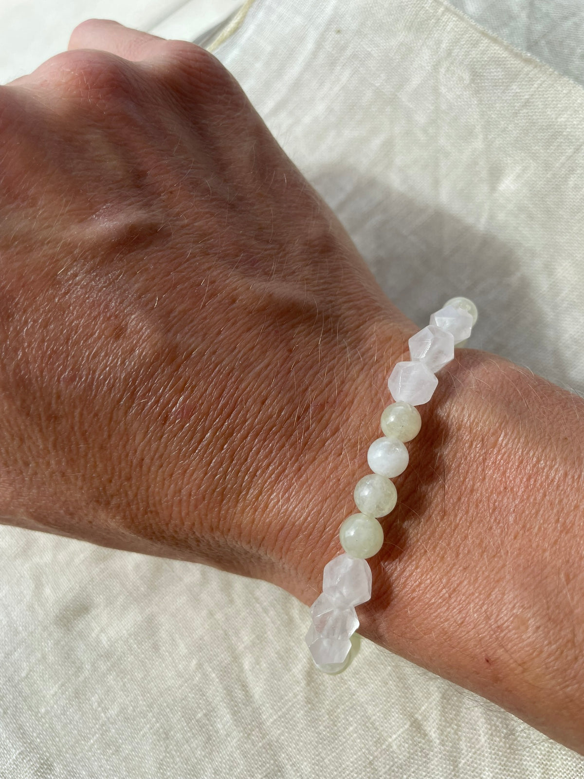 Handmade Misty Meadow gemstone bracelet worn on the wrist, highlighting its delicate natural colours and polished gemstones.