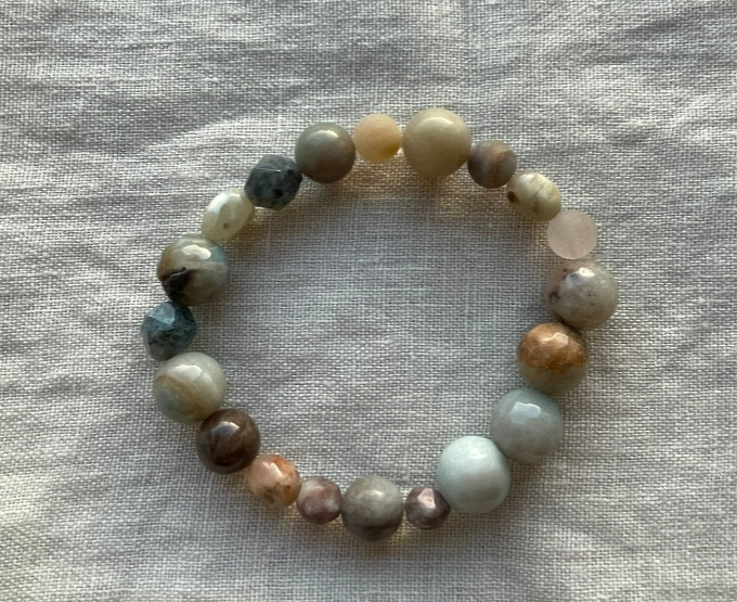 Coastal Dream Gemstone Bracelet showing a mix of pale aqua, beige, sandy brown, blush pink and teal natural gemstone beads on white linen, handmade in Denmark.