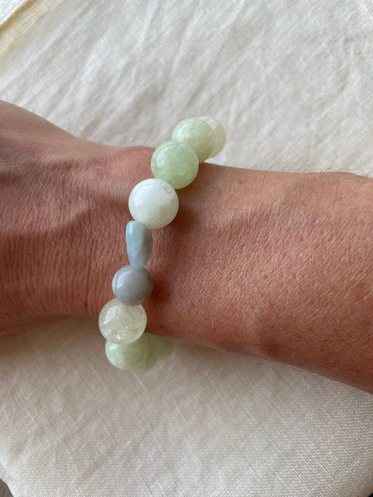 Serene Balance natural gemstone bracelet worn on the wrist, showing the delicate combination of green, blue, white and neutral gemstones.