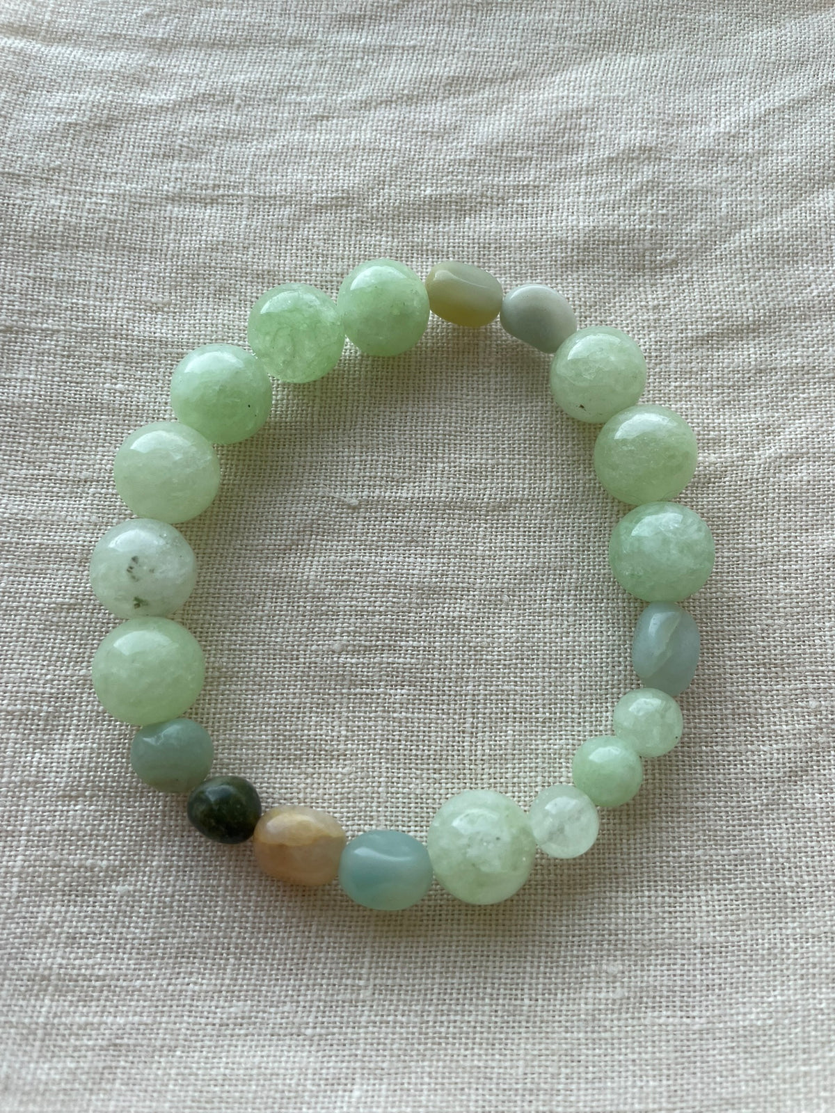 Green Harmony natural gemstone bracelet arranged in a circle, featuring polished green and blue-green gemstones.