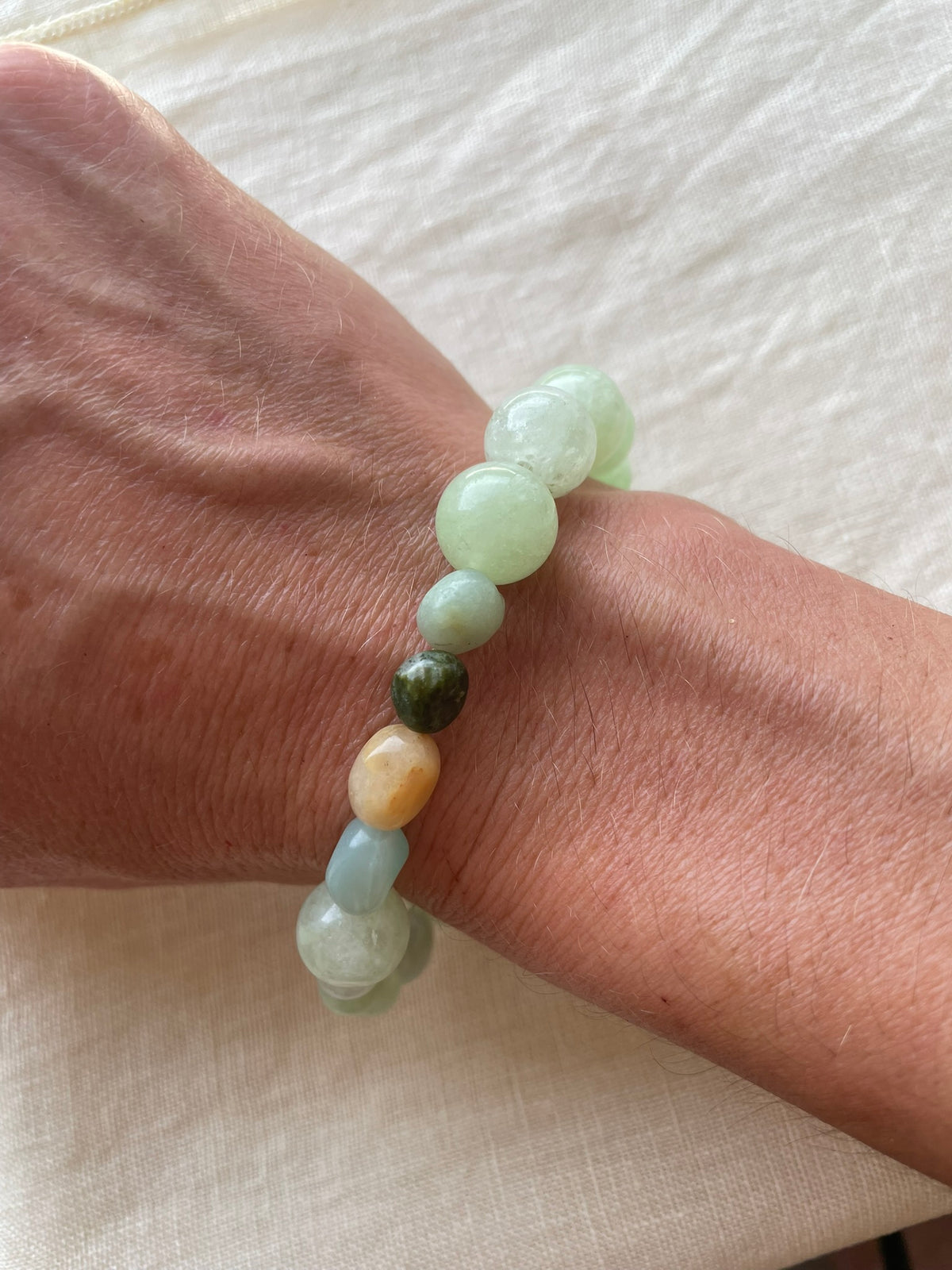 Green Harmony natural gemstone bracelet worn on the wrist, showing its soft green natural gemstones.