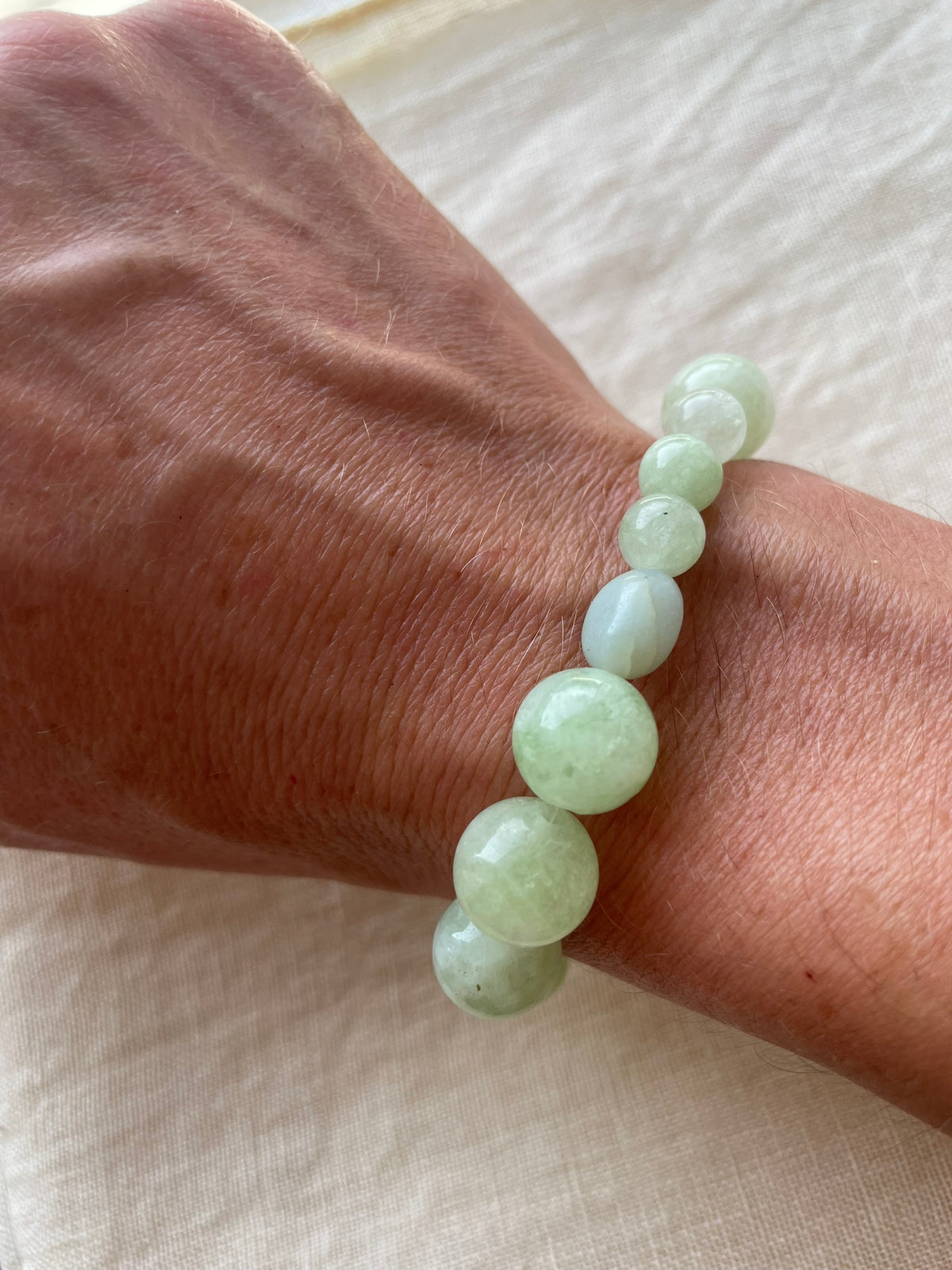 Green Harmony natural gemstone bracelet worn on the wrist in soft natural light.