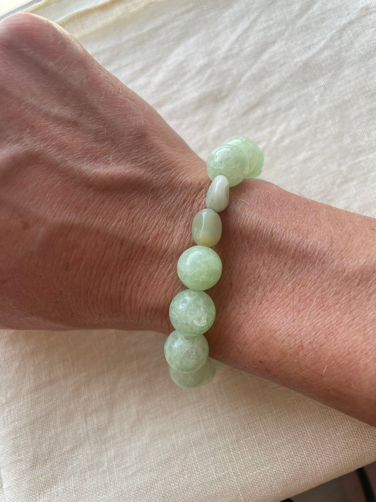Green Harmony natural gemstone bracelet in soft green and blue-green tones worn on the wrist.