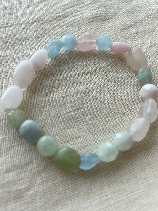 Pastel Serenity gemstone bracelet arranged in a circle, featuring natural pastel pink, white, blue and green gemstones.