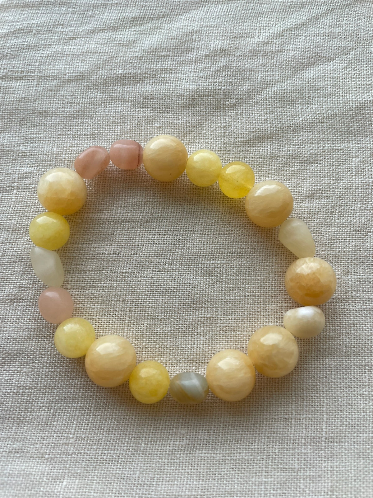 Golden Sunrise natural gemstone bracelet arranged in a circle, showing warm honey, peach and cream gemstones.