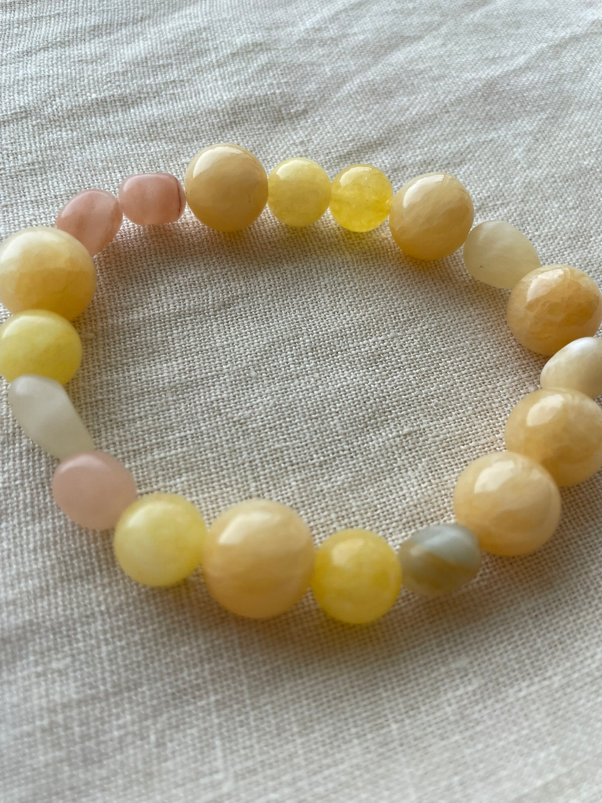 Close-up side view of the Golden Sunrise natural gemstone bracelet showing its warm golden and cream gemstones.