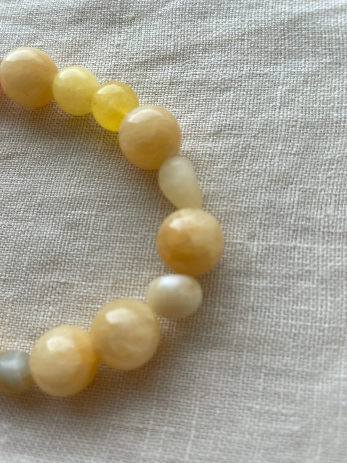 Close-up of Golden Sunrise bracelet featuring polished natural gemstones in golden, honey and peach tones.