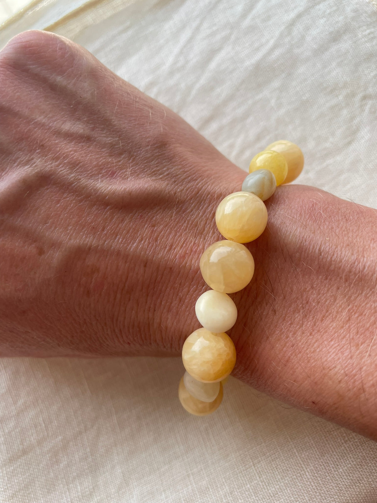 Golden Sunrise natural gemstone bracelet in warm honey, peach, cream and golden tones worn on the wrist.
