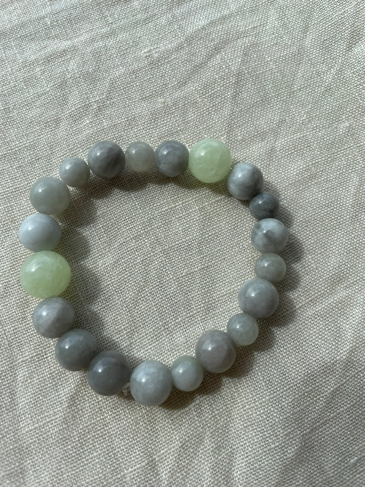 Ocean Calm natural gemstone bracelet arranged in a circle, featuring blue, grey and green natural gemstones.