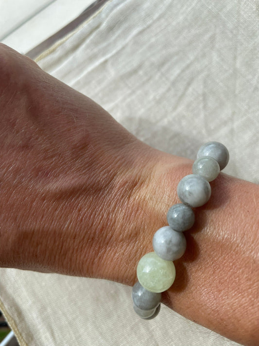 Handmade natural gemstone bracelet in soft ocean blue, misty grey and gentle green tones worn on the wrist.