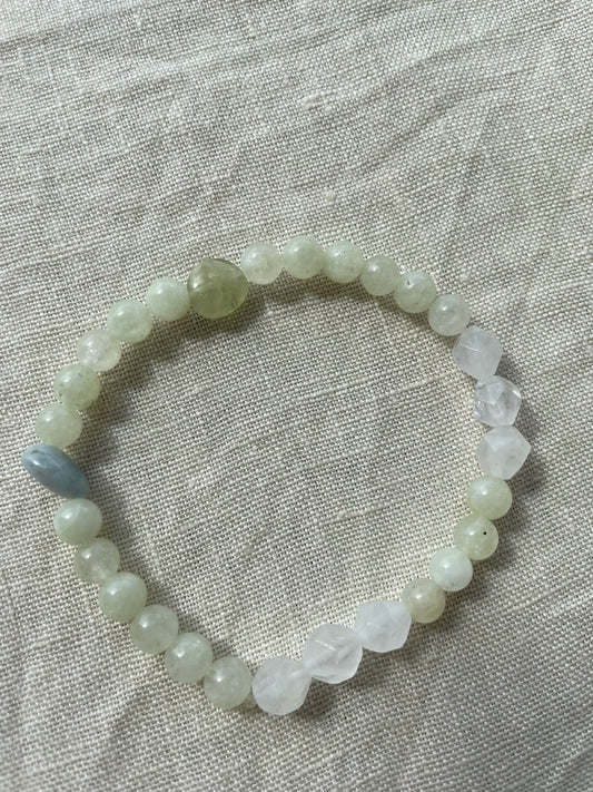 Misty Meadow natural gemstone bracelet arranged in a circle, featuring soft green, white and misty blue gemstones.