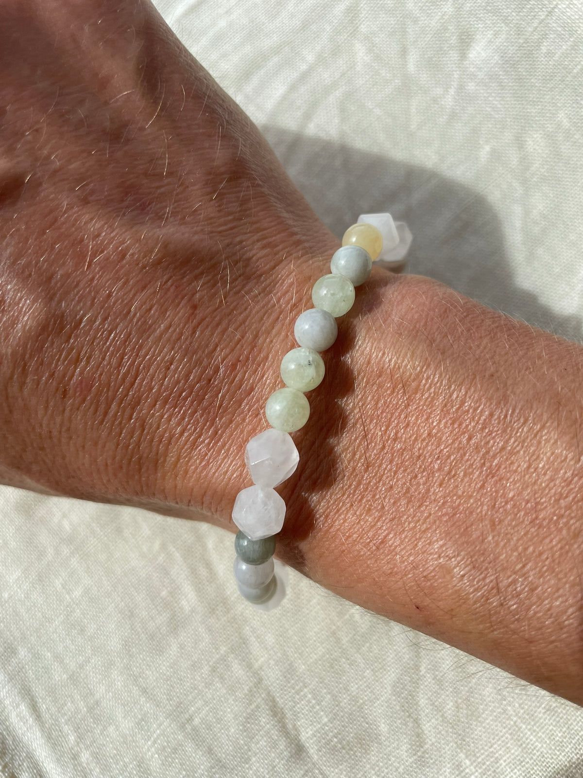 lose-up of the Yellow Forest gemstone bracelet worn on the wrist, highlighting its warm yellow and green natural tones.