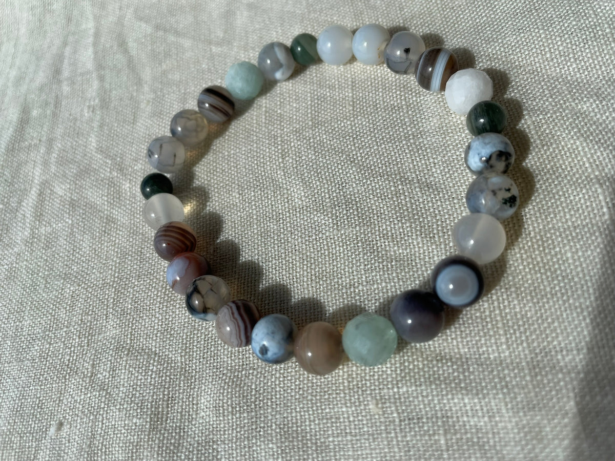 Close-up of the Forest Coast gemstone bracelet showing natural green, blue, white and brown tones and unique bead patterns.