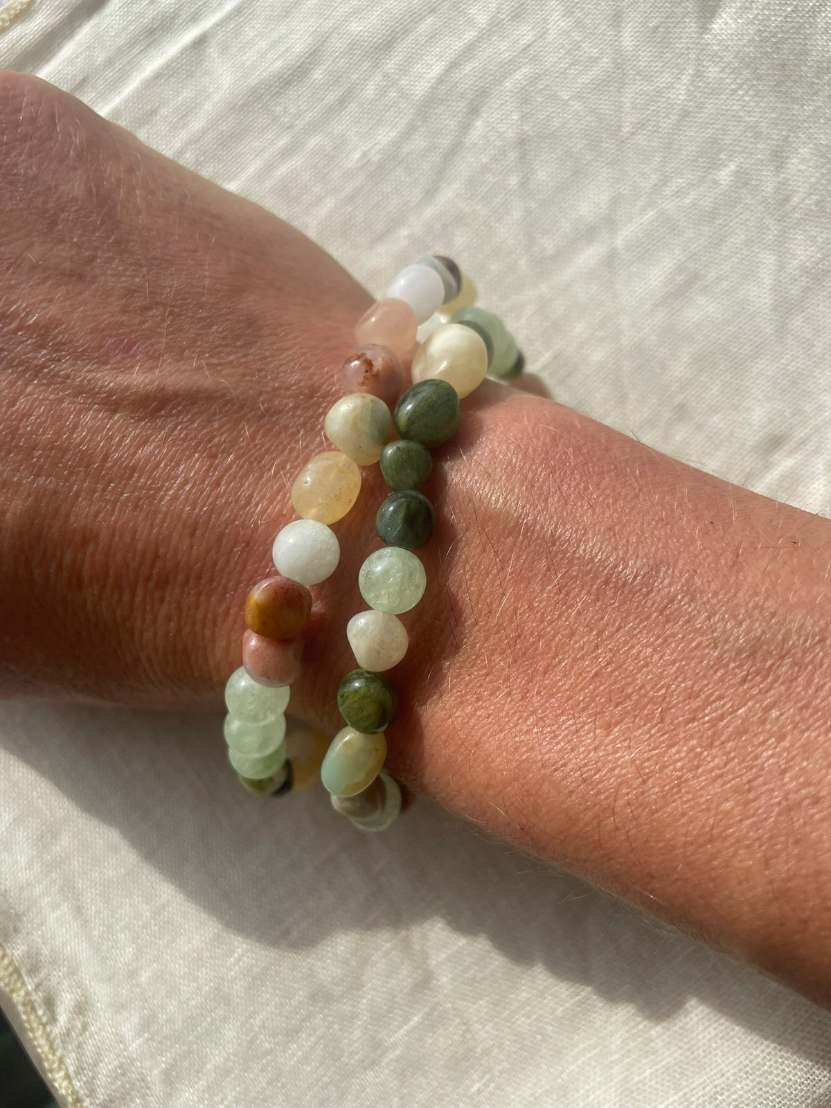 Handmade Forest Garden gemstone bracelet worn on the wrist, featuring green, white and subtle brown natural gemstones.