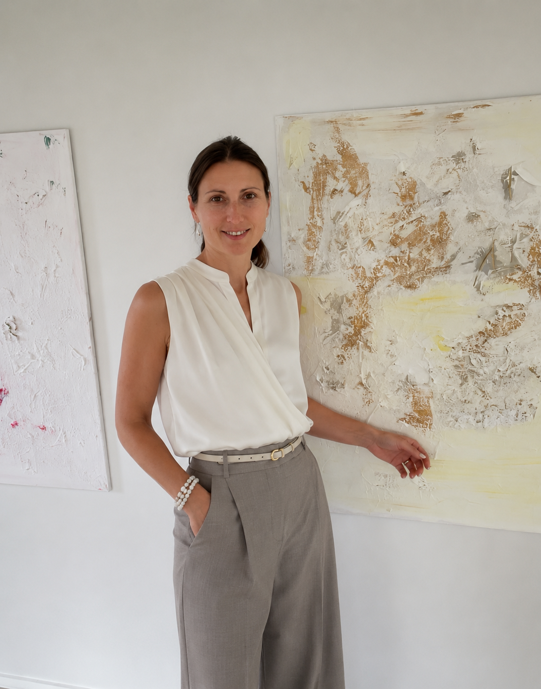 Victoria Lorenz standing between original abstract paintings in her Danish studio